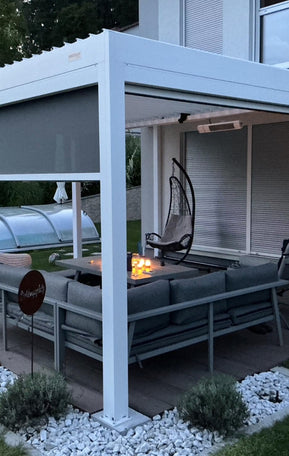 Pergolux Pergola mit LED-Beleuchtung an einem Haus, aufgenommen bei Dämmerung.