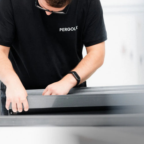 Pergolux-Mitarbeiter bei der sorgfältigen Montage eines Bauteils